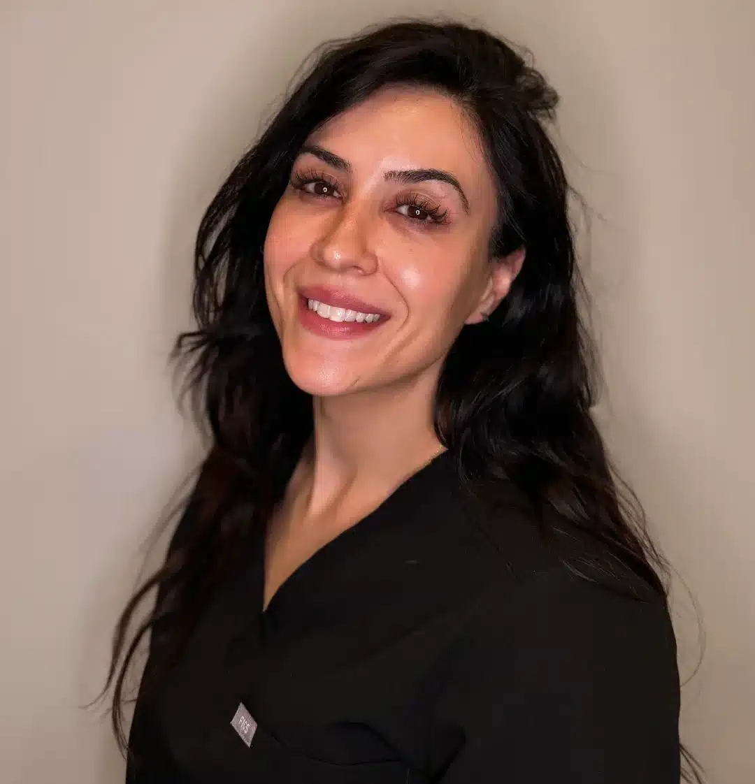 Photo of Christina from Liv Aesthetics LLC, smiling warmly in a black top. She stands against a soft, neutral background, conveying approachability and professionalism.